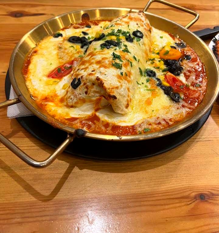 Burrito gratiné servi dans un plat en cuivre